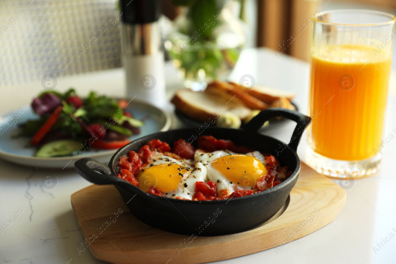 Tasty Shakshouka served on white table. Traditional Arabic dish Photo of Tasty Shakshouka served on white table. Traditional Arabic dish