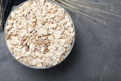 Photo of Bowl of oatmeal on grey table, top view. Space for text