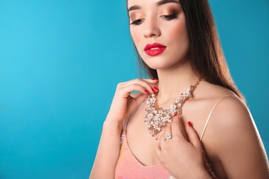 Photo of Beautiful woman with stylish jewelry on color background, space for text
