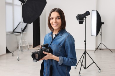 Photo of Professional photographer with camera in modern photo studio