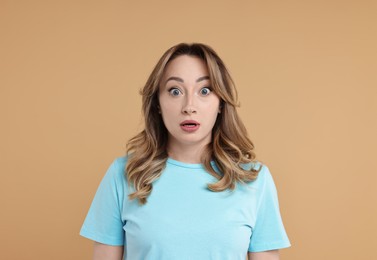 Photo of Portrait of surprised woman on beige background