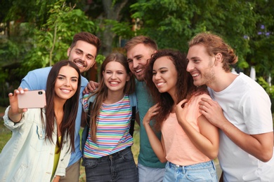 Photo of Happy young people taking selfie in park