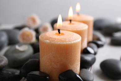 Photo of Beautiful composition with candles and spa stones on table