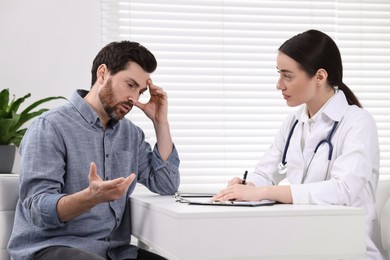 Photo of Doctor consulting patient during appointment in clinic