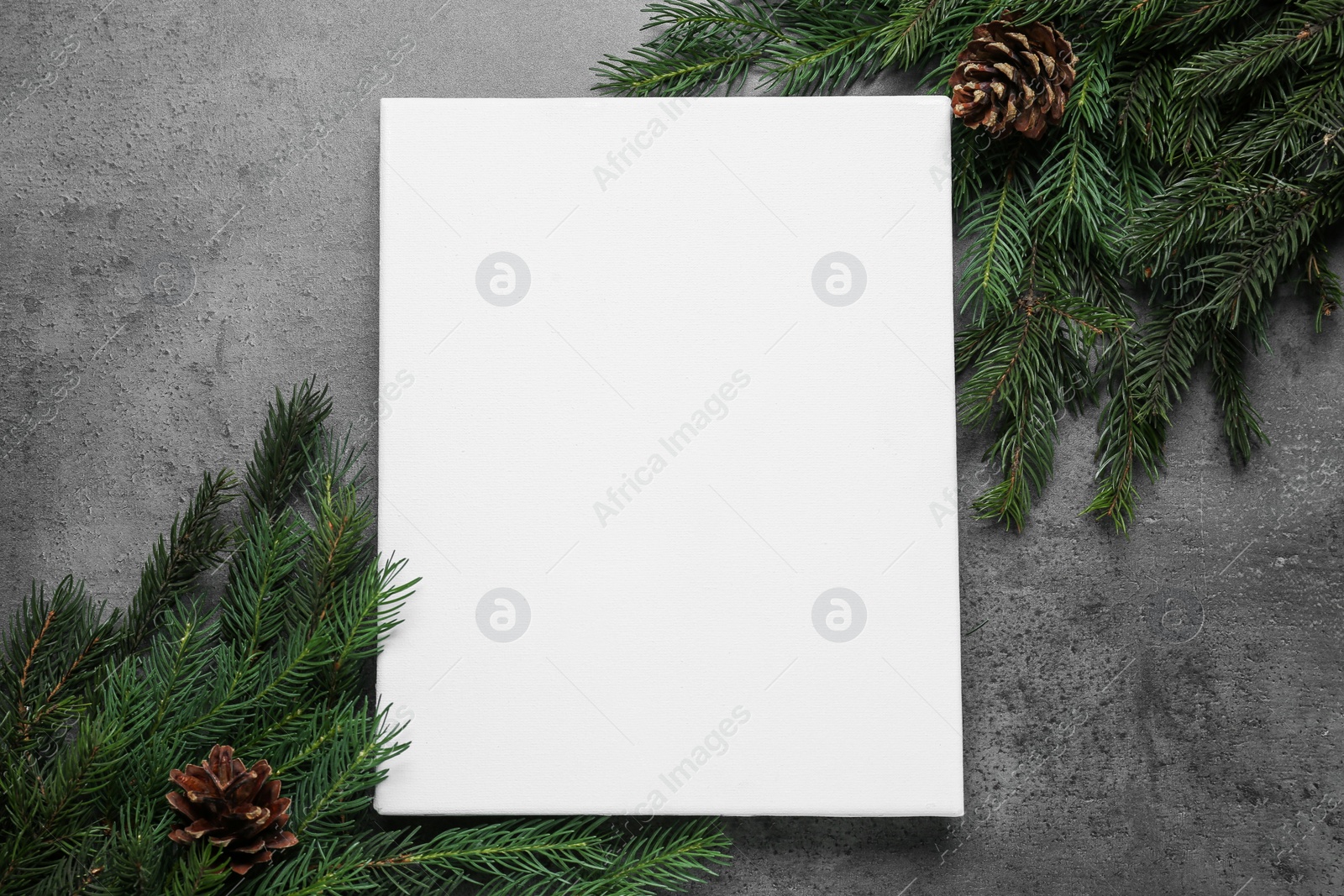 Blank canvas and Christmas decor on grey table, flat lay. Space for design Photo of Blank canvas and Christmas decor on grey table, flat lay. Space for design