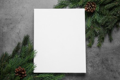 Photo of Blank canvas and Christmas decor on grey table, flat lay. Space for design