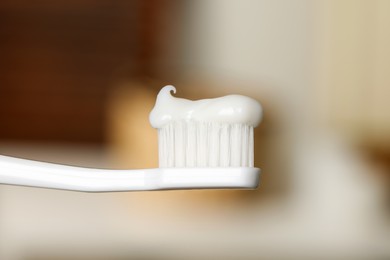 Photo of Plastic toothbrush with paste on blurred background, closeup