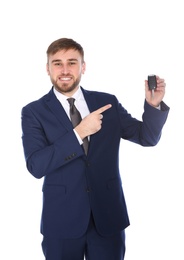 Happy young businessman with car key on white background