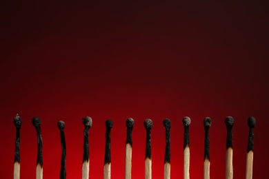 Photo of Line of burnt matches on color background. Space for text