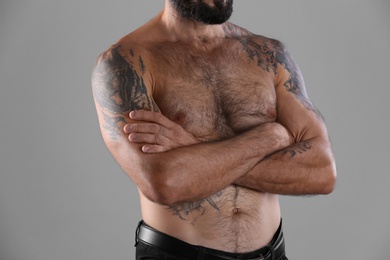 Photo of Tattooed man on grey background, closeup view