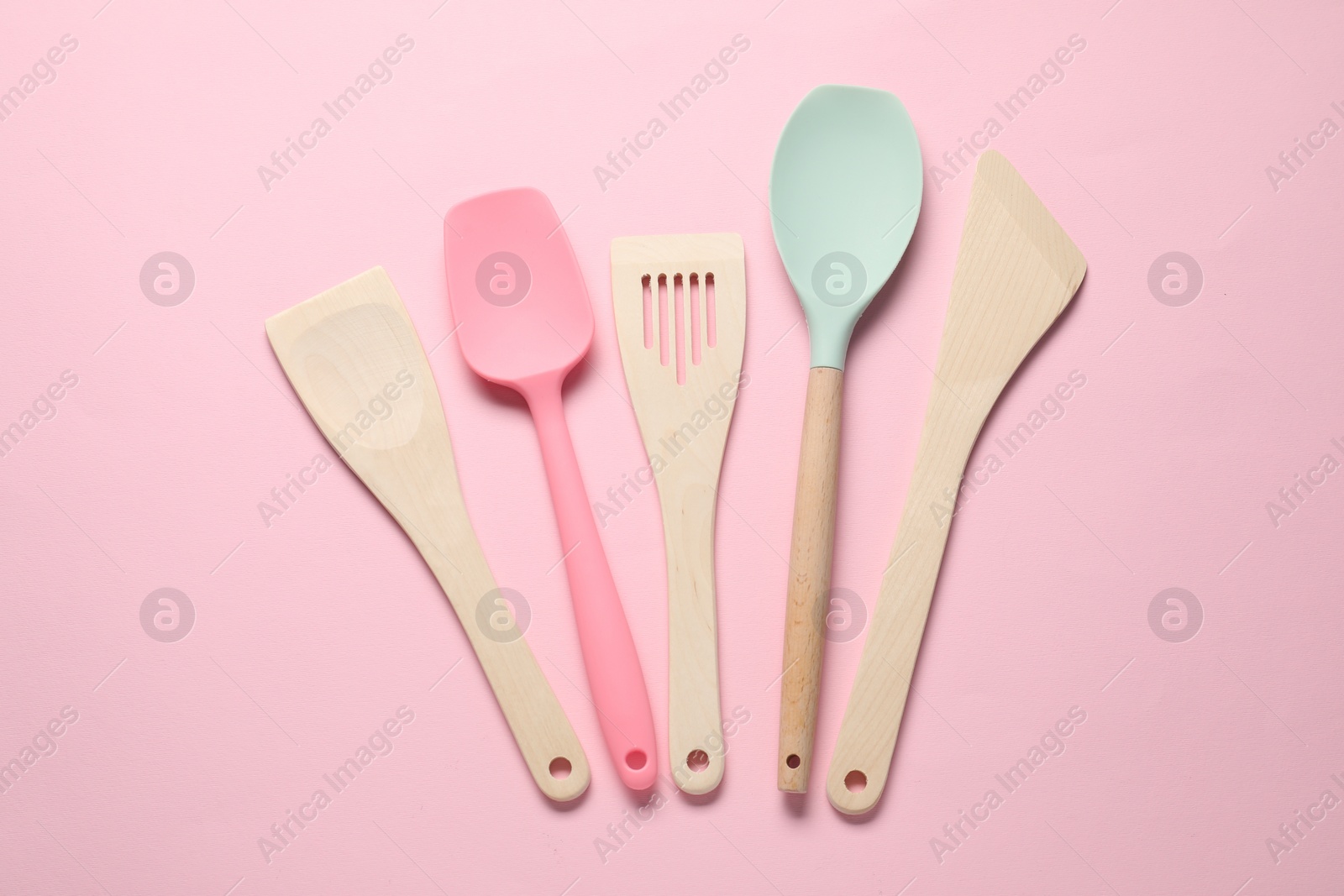 Photo of Different spatulas on pink background, flat lay