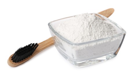 Photo of Glass bowl of tooth powder and brush on white background