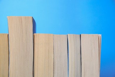 Collection of books on light blue background, closeup