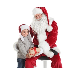 Little boy receiving gift box from authentic Santa Claus on white background