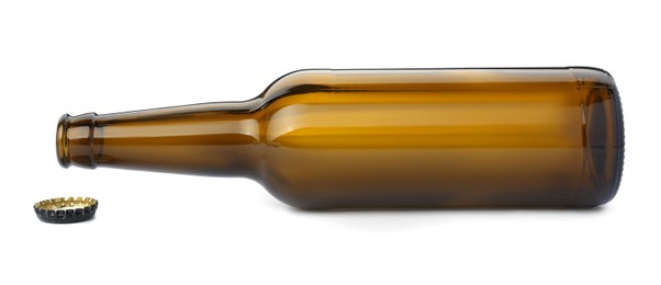 Photo of One empty brown beer bottle and cap isolated on white