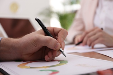 Photo of Business people working with charts and graphs at table in office, closeup. Investment analysis