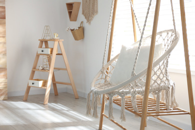 Photo of Comfortable hammock chair in stylish room. Home interior
