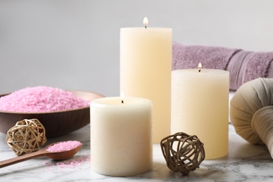 Photo of Aromatic candles and pink sea salt on white marble table