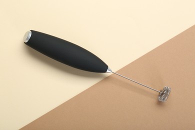 Photo of Black milk frother wand on color background, top view