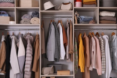 Photo of Wardrobe closet with different stylish clothes, accessories and home stuff