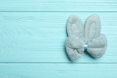 Photo of Cute hair clip on light blue wooden table, top view. Space for text