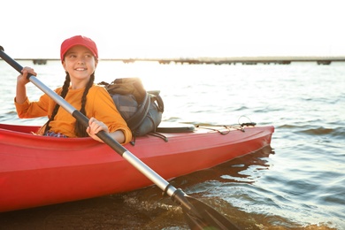 Photo of Happy girl kayaking on river. Summer camp activity