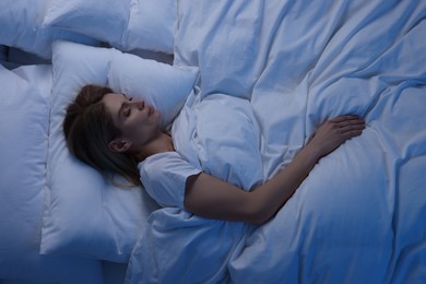 Photo of Woman sleeping in bed at night, above view
