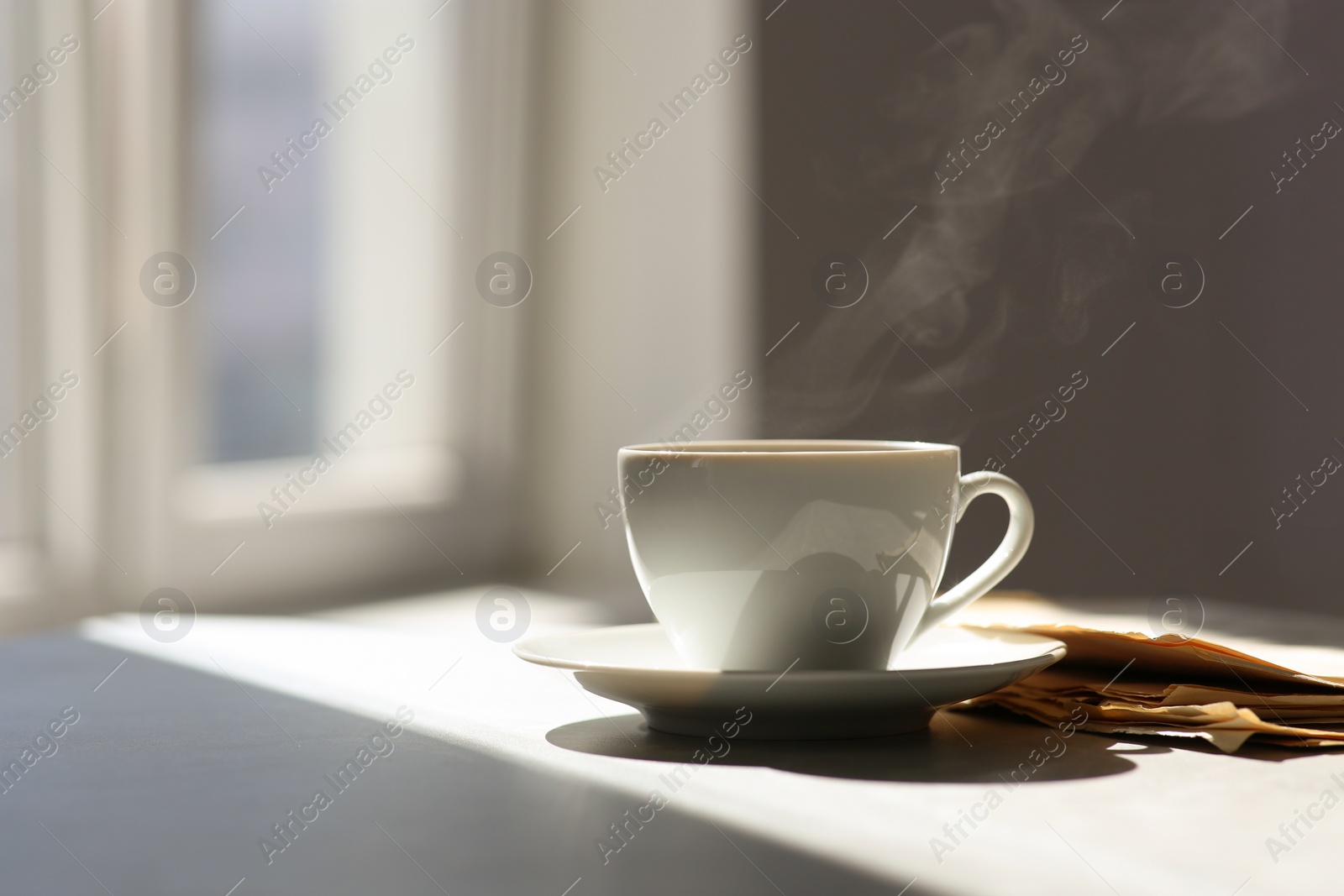 Photo of Delicious coffee and newspaper on sunlit table. Good morning