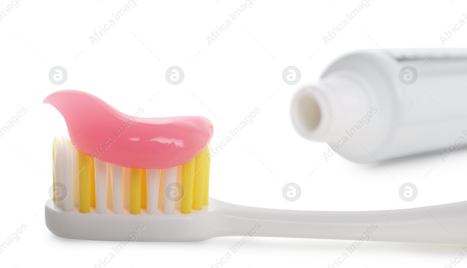 Photo of Brush with toothpaste and tube on white background, closeup