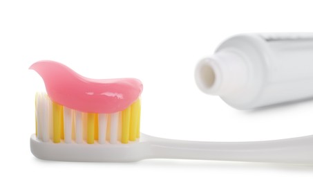 Photo of Brush with toothpaste and tube on white background, closeup