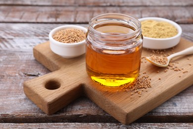 Photo of Jar with natural oil, mustard seeds and powder on wooden table