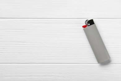 Photo of Stylish small pocket lighter on white wooden background, top view. Space for text