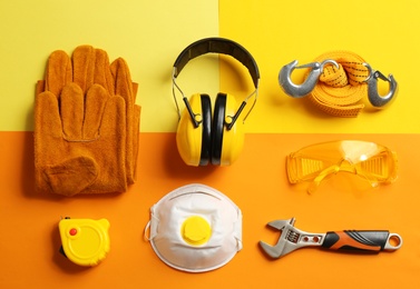 Photo of Flat lay composition with tools and safety equipment on color background