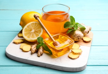 Photo of Ginger, honey, mint and lemon on light blue wooden table. Natural cold remedies