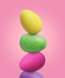 Image of Stack of bright Easter eggs on pink background
