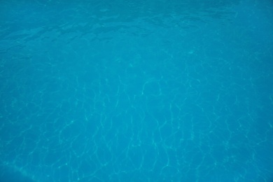 Surface of swimming pool with clean blue water as background