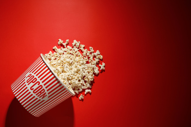 Photo of Delicious popcorn on red background, top view. Space for text