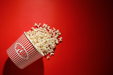 Delicious popcorn on red background, top view. Space for text