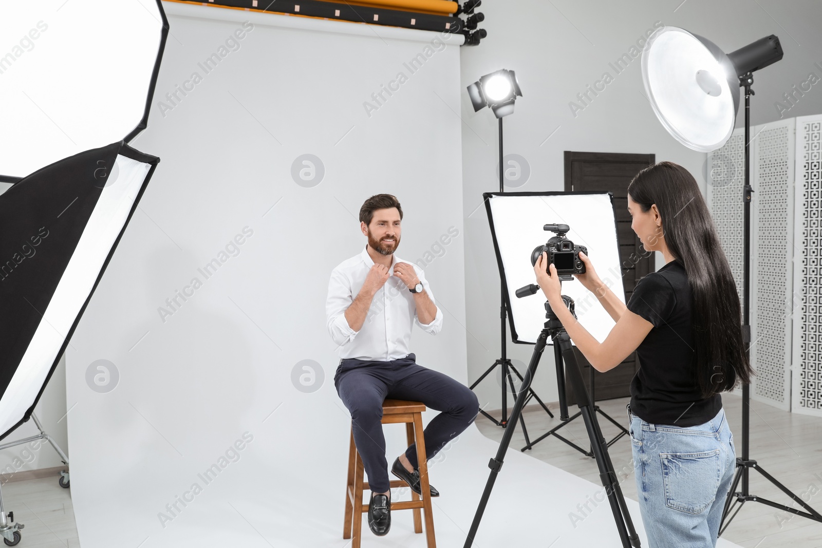 Photo of Professional photographer working with handsome model in modern photo studio