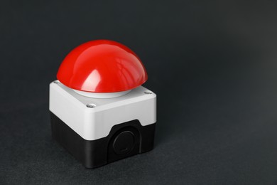 Photo of Red button of nuclear weapon on black background, closeup with space for text. War concept