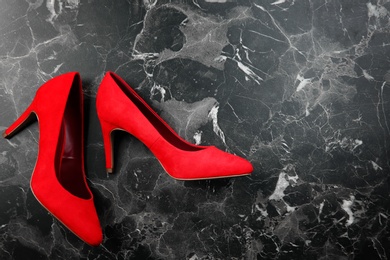 Pair of red female shoes on marble background