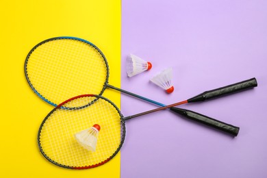Photo of Rackets and shuttlecocks on color background, flat lay. Badminton equipment