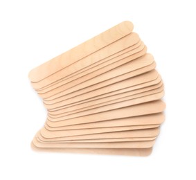 Photo of Disposable wooden spatulas for depilatory wax on white background, top view