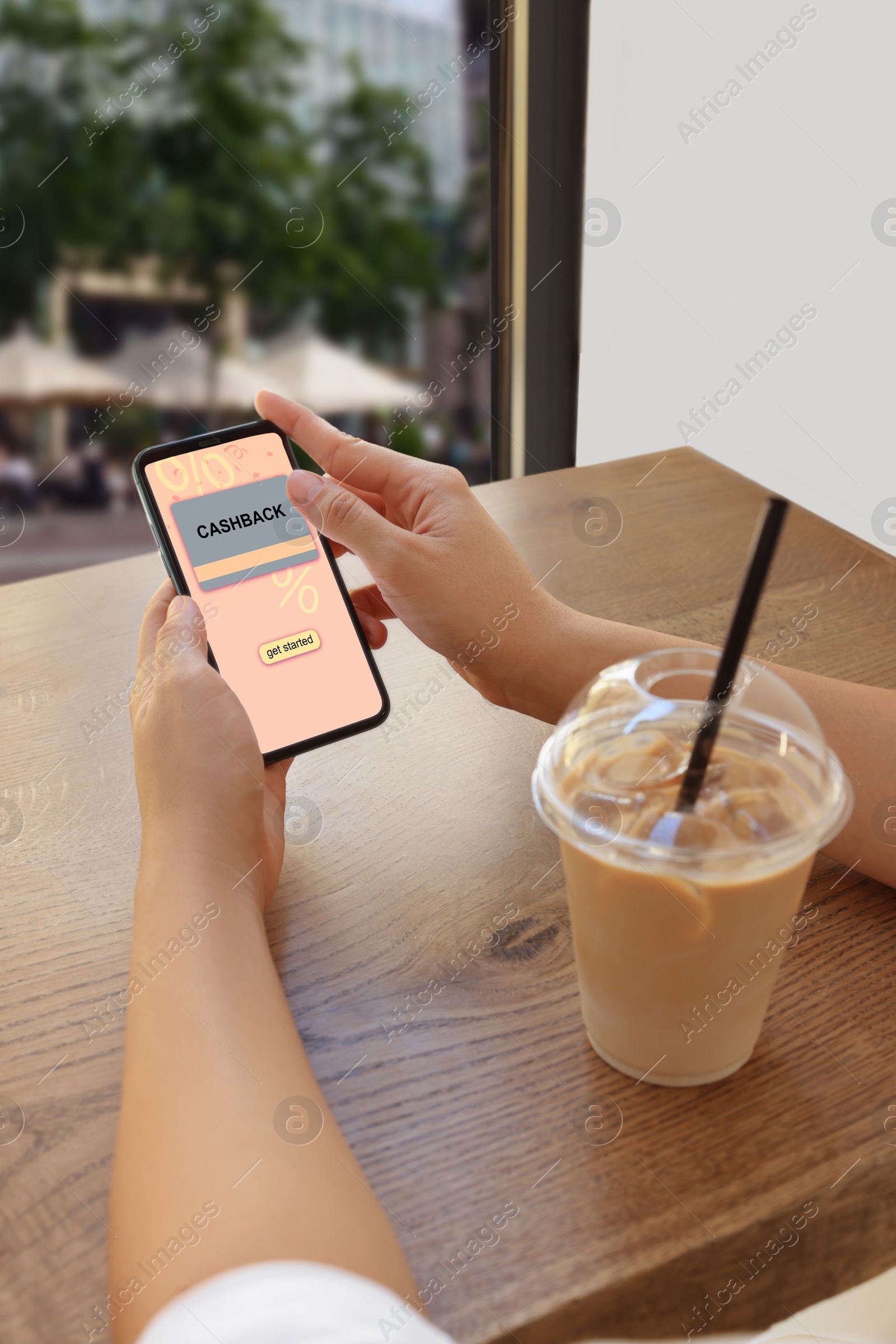 Image of Cashback. Woman using smartphone at table indoors, closeup. Illustration of credit card and percent signs on device screen