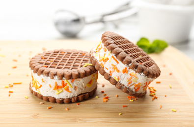 Sweet delicious ice cream cookie sandwiches on wooden table, closeup