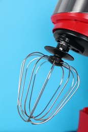 Photo of Closeup view of modern red stand mixer on turquoise background