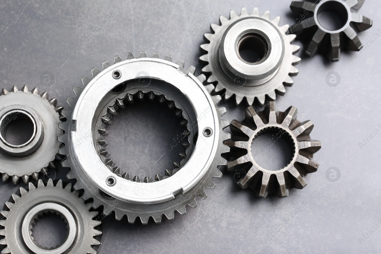 Photo of Different stainless steel gears on grey background, flat lay