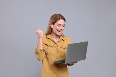 Photo of Emotional woman with laptop on light grey background