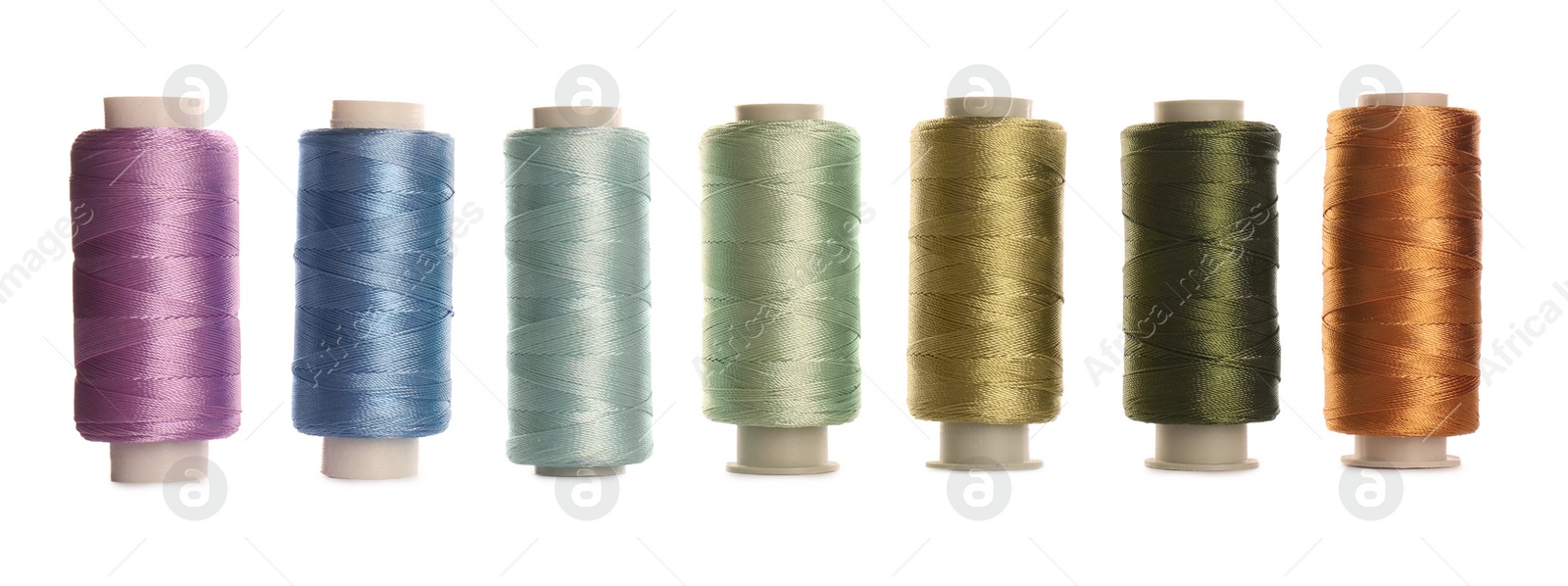 Photo of Set of colorful sewing threads on white background