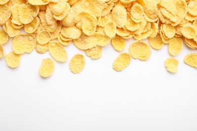 Photo of Breakfast cereal. Tasty corn flakes on white background, flat lay. Space for text